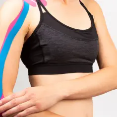 Sportowiec z kolorowymi tejpy na plecy i ramię, wspierające mięśnie.