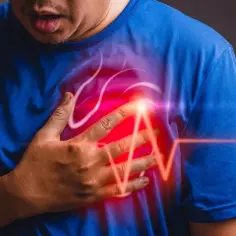 Mężczyzna trzymający się za klatkę piersiową, z czerwoną poświatą i linią EKG.